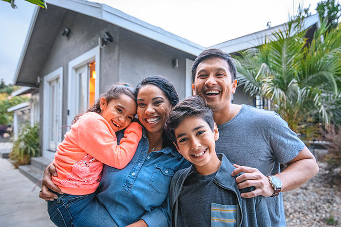 happy family standing in front of house