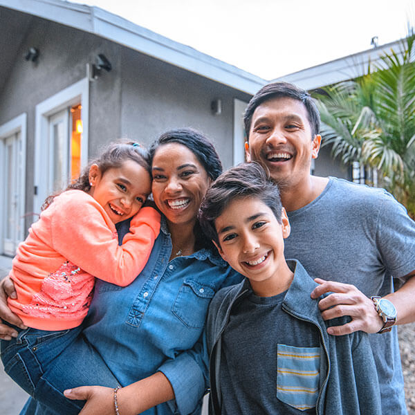happy family standing in front of house