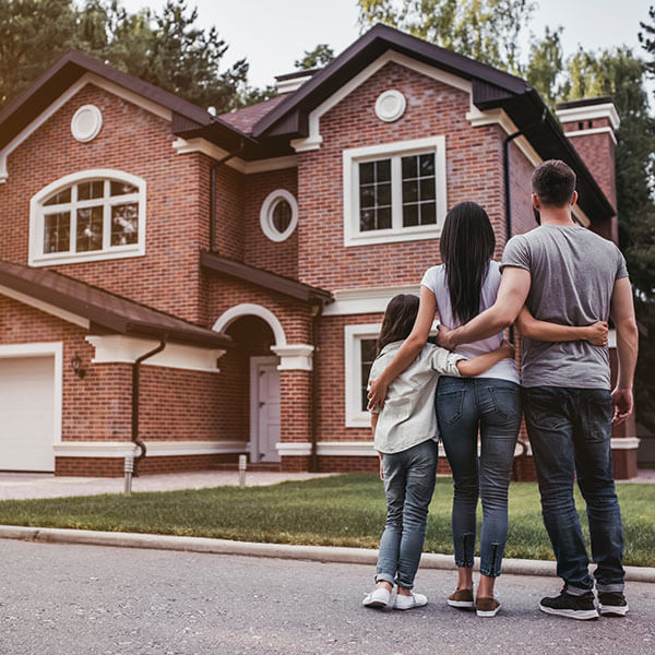 back view of happy family hugging near modern home